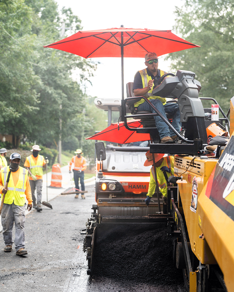 APCC, Employees working on road, red umbrella, employee on paving machine