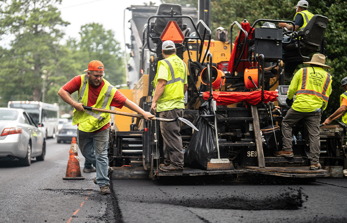 APCC, Employees on paving machine, one employee shoveling, paving, 23137_BUILDWITT_1237