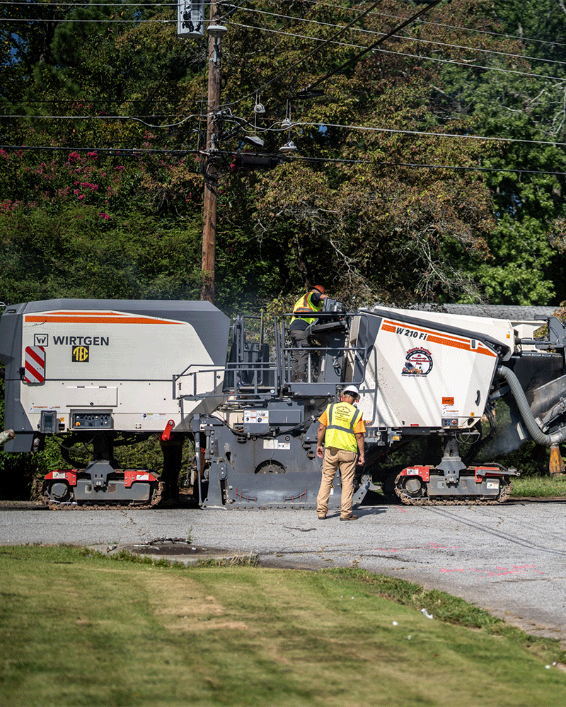 APCC, two employees working with milling machine on residential street, 23137_BUILDWITT_2030 cropped